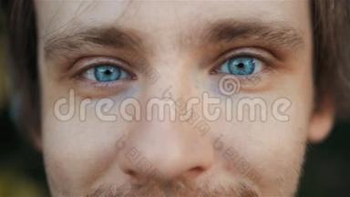 具有美丽蓝眼睛的帅哥的高度细致的特写镜头，户外