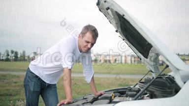 看着汽车发动机的人。 修理破车的人