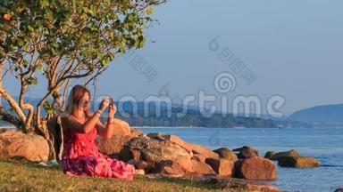 沙滩上的红色小女孩在日落时被公鸡拍照