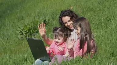 妈妈带着<strong>女儿</strong>在草地上拿着笔记本电脑。 阳光明媚的一天，<strong>一家人</strong>在公园里。