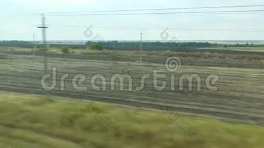 从移动列车的窗口拍摄。 俄罗斯秋季景观：田野、森林、种植、天空