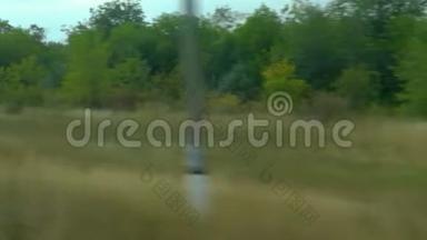 从移动列车的窗口拍摄。 俄罗斯秋季景观：田野、森林、种植、天空