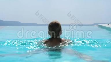 年轻女子在游泳池里放松，欣赏桑托里尼的<strong>美景</strong>