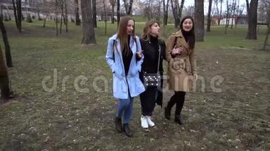 女孩的友谊。 三个年轻漂亮的女孩在城市公园散步。 他们很开心。 女孩们很高兴认识