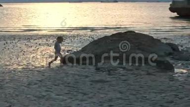 小女孩在日落的低潮时沿着湿沙滩奔跑