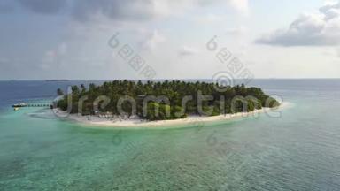 相机围绕着一个圆形的热带环礁岛度假酒店飞来飞去，那里有白沙棕榈树和绿松石