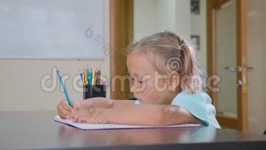 小可爱的女孩坐在教室里写作业本