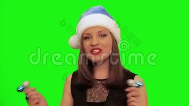 戴着圣诞帽的漂亮女人跳舞唱圣诞歌曲，唱着绿色的彩幕