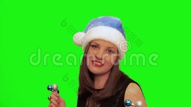 戴着圣诞帽的漂亮女人跳舞唱圣诞歌曲，唱着绿色的彩幕