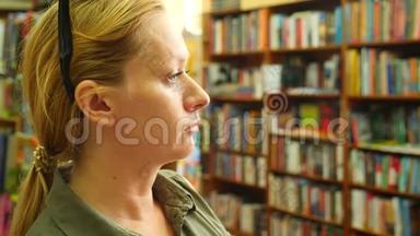 一个女人站在<strong>图书馆</strong>的肖像。 背景的<strong>书架</strong>。 4k，慢镜头
