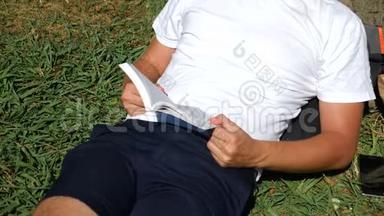 帅哥坐在公园的草地上，<strong>树下</strong>有一棵<strong>树</strong>，<strong>看书</strong>，4k，慢动作
