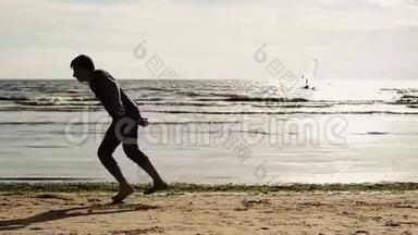 人在前面的镜头下在海滩上做杂技表演. 波浪。 假期。 夏日