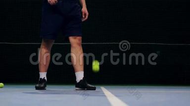 网球运动员拿着球准备发球。 特写双脚网球选手准备发球.. 敲开了