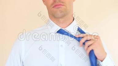 一个商人脱下蓝色领带，解开衬衫上的<strong>扣子</strong>。 4K，慢动作，超级特写。 空间空间