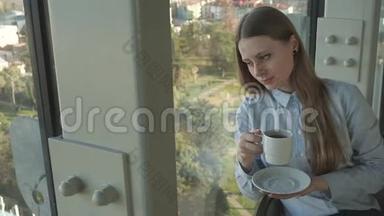 女孩在时尚餐厅的窗户边喝茶