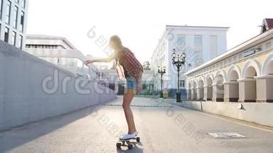 女人在日出时玩滑板。 滑板上的腿，走向成功