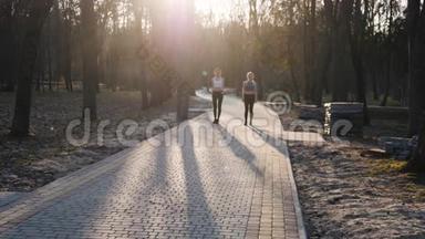 两名运动女子在公园的混凝土<strong>跑道上</strong>缓慢地跑着。 健康健身理念