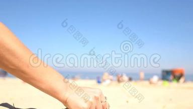 沙滩上一个女人手里的沙子。