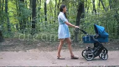 妈妈带着婴儿车在<strong>公园</strong>里<strong>散步</strong>。 夏季自然背景。