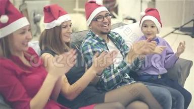 戴着圣诞帽的家人正在欣赏小女孩的新年表演。