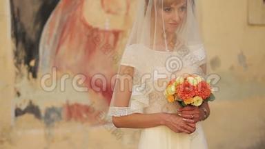 迷人的金发新娘带着结婚花束展望未来