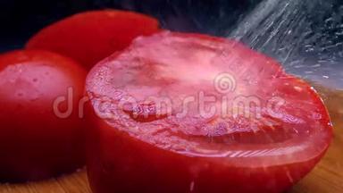 在切好的红番茄上洒水。冷色调。超慢镜头