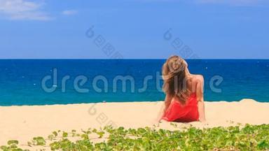 穿红衣服的金发女孩光着脚坐在沙滩上转镜头