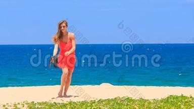穿红衣服的金发女孩在沙滩上脱掉凉鞋