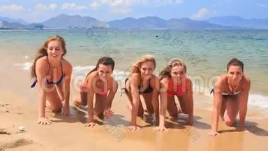 穿着比基尼的啦啦队员沿着沙滩微笑排队