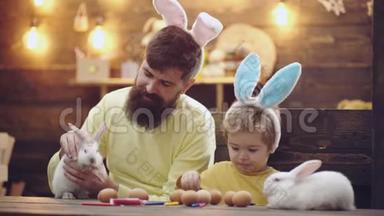 幸福的家庭正在为复活节做准备。 可爱的小男孩戴着兔子耳朵。 美丽的儿童画复活节