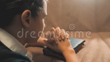 小女孩在夜里祈祷。 小女孩用手祈祷。 小女孩圣经在圣经中祈祷