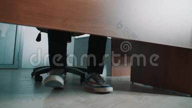 无法辨认的办公室工作人员在桌子<strong>底下</strong>踩着运动鞋