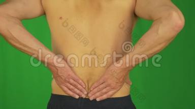 男人用手掌摩擦他的下背部，因为背部疼痛。