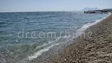 海浪在卵石海滩上特写，太阳在海浪中反射，地中海