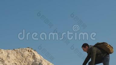 登山者在白色的岩石上一个接一个地爬。 游客们互相伸手，爬到山顶。 团队合作