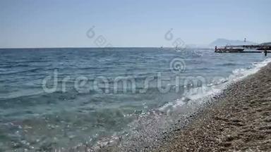 海浪在卵石海滩上特写，太阳在海浪中反射，地中海