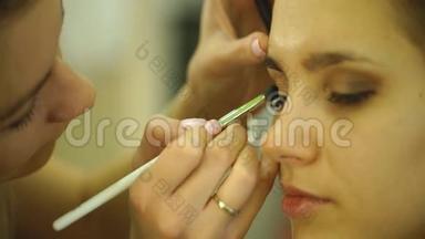 化妆的过程。 化妆师在模特脸上用刷子工作。