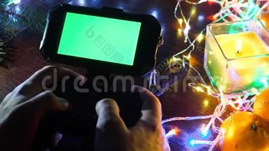 游戏垫与智能手机在黑色背景桌子与彩色灯，圣诞节新年作文。 智能手机游戏