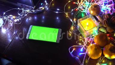 黑色背景桌子上的智能手机，五颜六色的灯光，圣诞新年作文。 智能手机游戏
