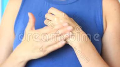 女人正在为柔软的护肤品而捏手。 一个女人用手霜在她的背景上涂抹她的手