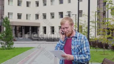 一个年轻的学生来到大学的背景下，打电话，拿着重要的文件
