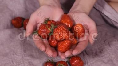 孩子搓手。 女孩带着一<strong>大盘</strong>草莓，看着相机，孩子手里拿着浆果。 高清高清