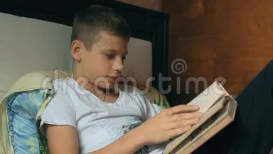 小男孩在沙发上看书。 儿童<strong>读物</strong>。 <strong>孩子</strong>做作业