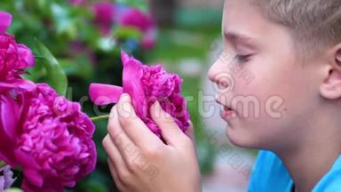 一个小可爱的宝宝轻轻地享受着花香.. 孩子<strong>拿起</strong>一朵花，吸入它的芬芳。 化名