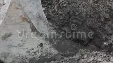 慢速挖掘机斗在土堆和泥土下拉混凝土板