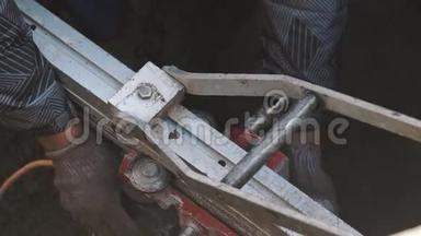 工人用手扳动沟渠中的金属工业机械
