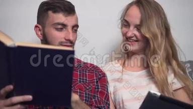 年轻夫妇使用平板电脑阅<strong>读书籍</strong>