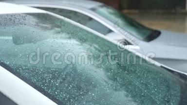 雨点落在外面停着的汽车的玻璃上。 4k，慢镜头拍摄4k，