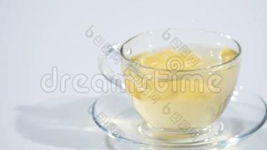 在一个装有<strong>红茶</strong>的茶托上的杯子里，一片柠檬倒在白色的<strong>背景</strong>上，慢着。