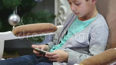 男孩在圣诞树附近玩手机、儿童和智能手机